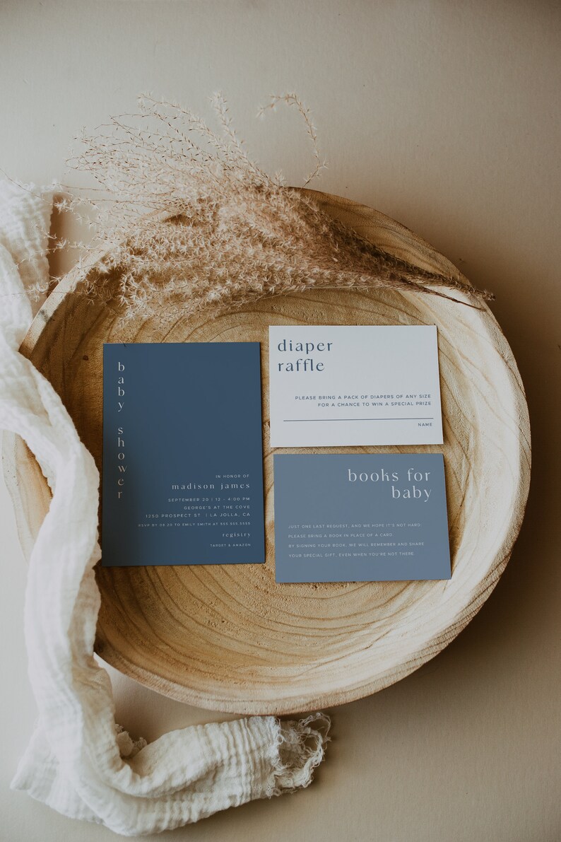 May include: Two blue cards with white text on a wooden tray. The top card says "diaper raffle" and the bottom card says "books for baby".