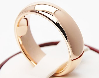 Puede incluir: Una banda de boda de oro rosa con un acabado liso y pulido.