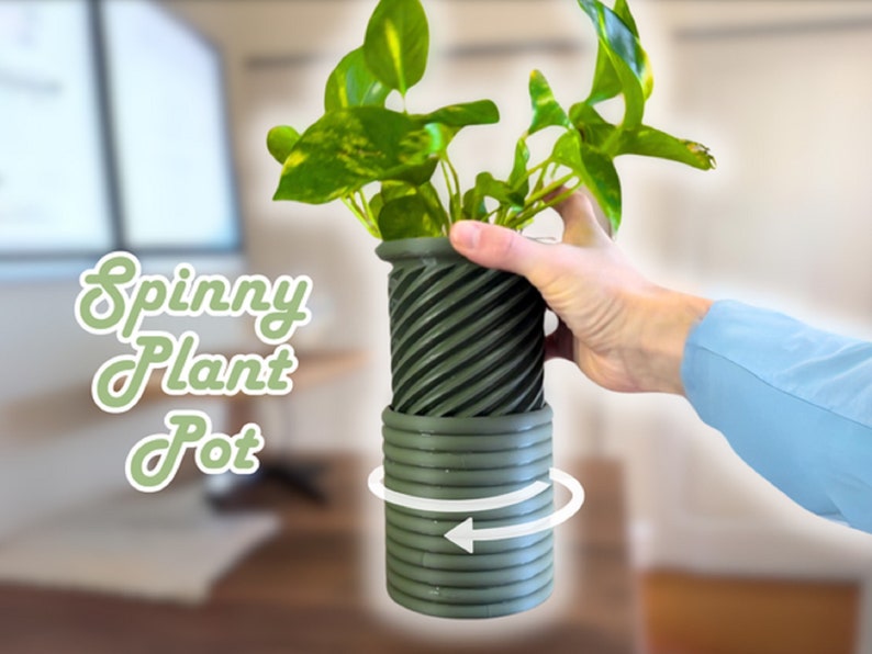 May include: A green plant pot with a spinning base. The pot is made of a textured material and has a dark green color. The text "Spinny Plant Pot" is written in green on a white background.