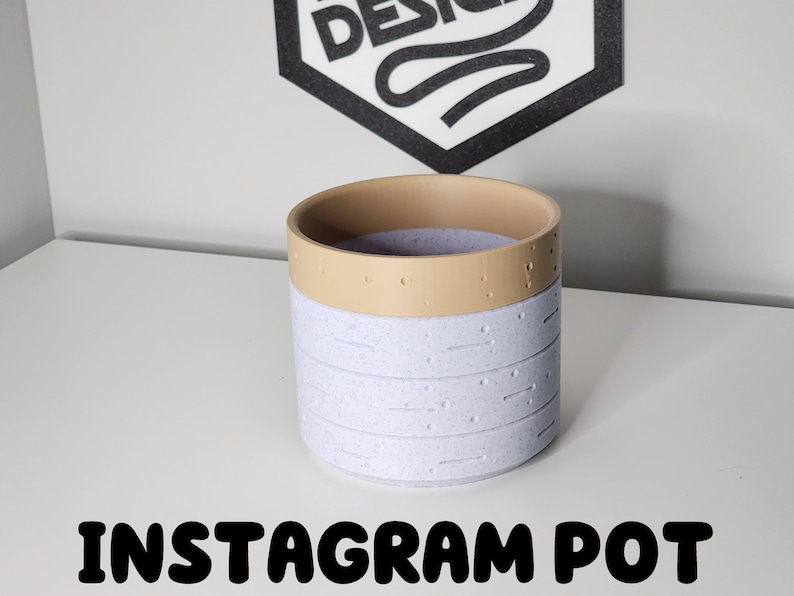 May include: A white ceramic planter with a light brown rim and a speckled texture. The planter has the text "INSTAGRAM POT" printed below it.
