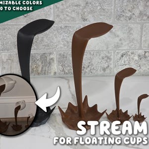 Puede incluir: Tres soportes decorativos para tazas flotantes, en negro y marrón. Los soportes tienen forma de cisne con una base ancha y un cuello curvo. La imagen también incluye un pequeño recuadro que muestra una taza en uso. El texto dice "Stream for Floating Cups."