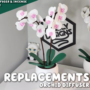 Puede incluir: Difusor de orquídeas blanco con flores rosas y blancas, hojas verdes y una maceta blanca. El texto "REPLACEMENTS ORCHID DIFFUSER" está en la parte inferior de la imagen. La esquina superior izquierda de la imagen tiene el texto "OIL DIFFUSER & INCENSE HOLDER".