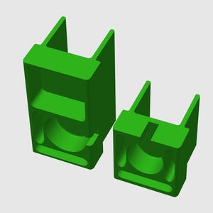 May include: Two bright green, three-dimensional, U-shaped brackets of varying heights. Each bracket features a rectangular base with a central circular cutout, a vertical slot, and two parallel upright arms extending from the top surface.