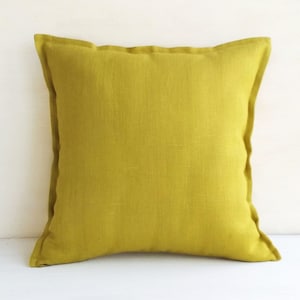 May include: A solid yellow linen pillow cover. The pillow cover is made of a soft, natural fabric and has a simple, elegant design.