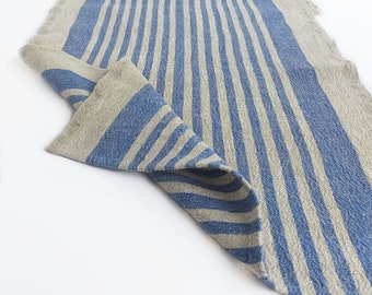 May include: A blue and natural linen striped table runner. The runner is folded in half and the blue stripes are visible.