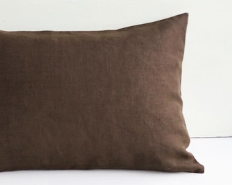 May include: A brown linen pillow with a smooth, even texture. The pillow is rectangular and has a simple, understated design.