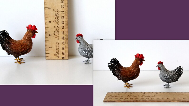 May include: Two handmade felt chickens, one brown with a red comb and one gray with a red comb. The chickens are standing on a white surface next to a wooden ruler.
