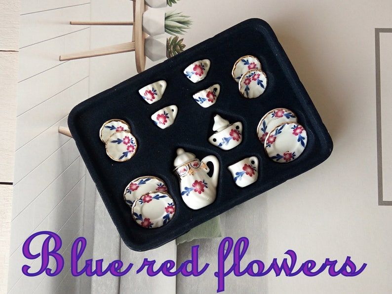 May include: A miniature tea set with a blue and white floral pattern. The set includes a teapot, creamer, sugar bowl, cups, and saucers. The set is displayed in a black velvet box.