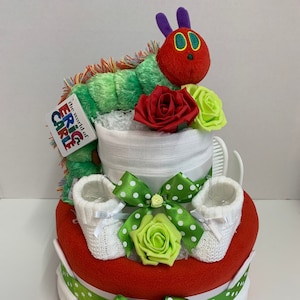 2 tier nappy cake in a hungry caterpillar theme made with nappies, red baby blanket, white muslin square, soft knit booties, brush set, hat, bib, scratch mittens and caterpillar soft toy. Gift wrapped with clear cellophane and ribbons and bow