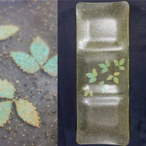 a vintage transparent snack tray embedded with gold flecks and green leaves