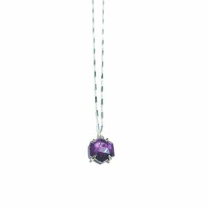 May include: A silver necklace featuring a faceted, deep purple amethyst gemstone pendant. The gemstone is held in a silver setting and hangs from a delicate silver chain. The pendant has a geometric shape.
