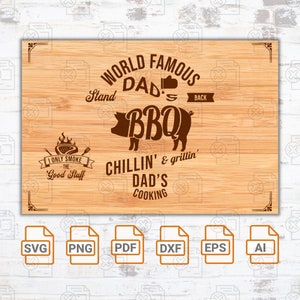 May include: A brown wooden sign with the text "World Famous Dad's BBQ Stand" and "Chillin' & grillin' Dad's Cooking". The sign also features a cartoon pig with the word "BBQ" inside. The sign is surrounded by a brown frame. Below the sign are six icons for different file formats: SVG, PNG, PDF, DXF, EPS, and AI.
