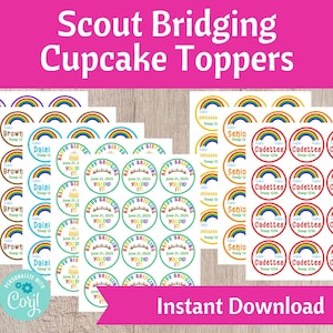 Könnte beinhalten: Druckbare Cupcake-Topper mit einem Regenbogen-Design und dem Text "Happy Bridging You Did It!" und "Cadettes Troop 1234". Die Topper sind für eine Scout-Übertrittszeremonie konzipiert.