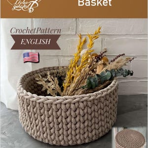Könnte beinhalten: Ein beige gehäkelter Korb gefüllt mit getrockneten Blumen und Blättern. Der Korb hat ein dickes, strukturiertes Gewebe und eine runde Form. Das Bild enthält den Text "Crochet Pattern Basket" und "ENGLISH". Ein zusätzliches Häkelmuster für den Deckel des Korbes ist ebenfalls enthalten.