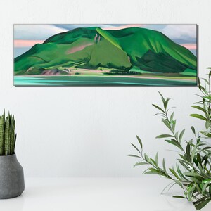 May include: A painting of a green mountain with a pink sky in the background. The mountain is reflected in the water in the foreground.