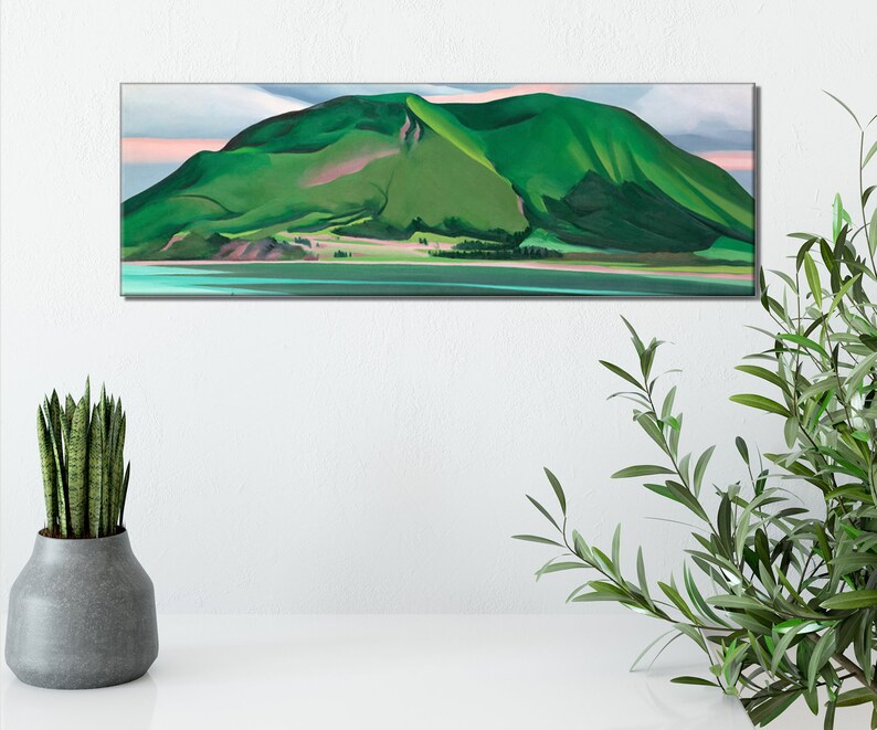 May include: A painting of a green mountain with a pink sky in the background. The mountain is reflected in the water in the foreground.