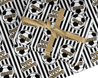 Peut inclure: Papier d'emballage rayé noir et blanc avec des ballons de football dorés et le nom "HENRY" répété sur toute la surface. Le texte "Joyeux anniversaire" est également répété sur toute la surface.