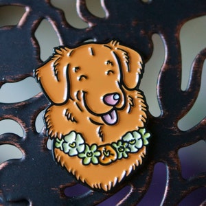 A Toller pin badge shown resting on a metal lattice.