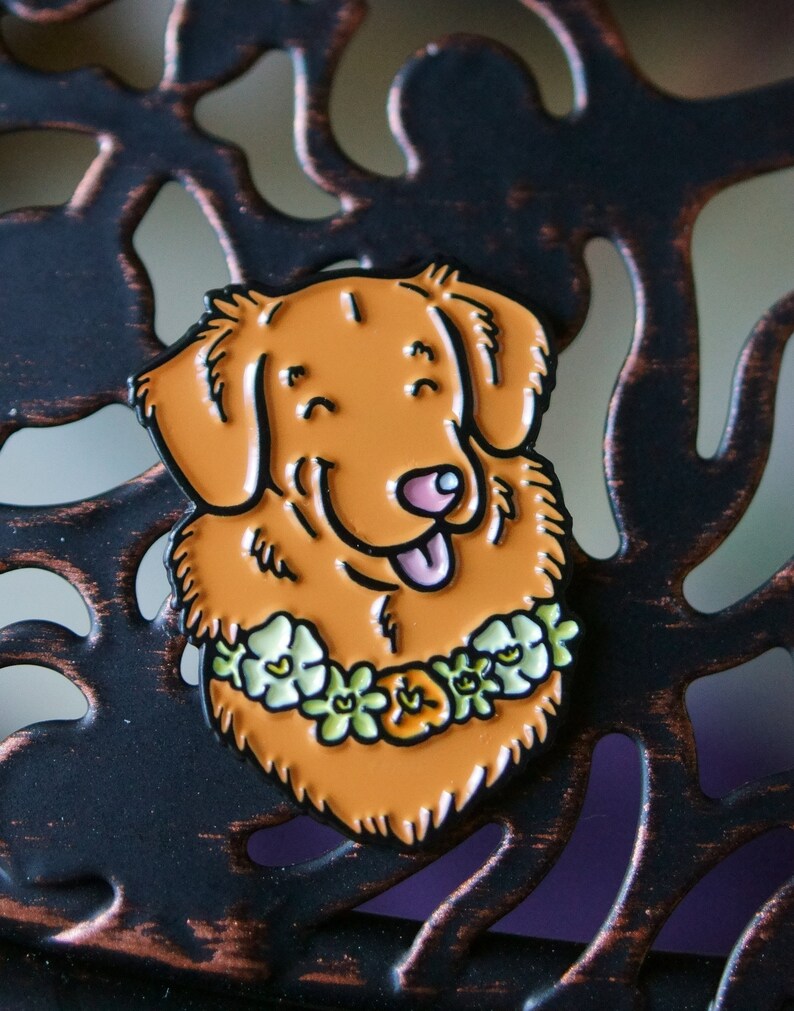 A Toller pin badge shown resting on a metal lattice.