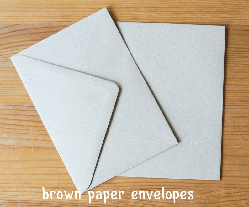 May include: Two brown paper envelopes on a wooden surface. The envelopes are blank and have a rough texture.