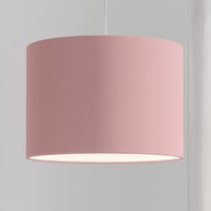 Pode incluir: Um abajur de tecido rosa com interior branco. O abajur é cilíndrico e tem uma textura lisa e uniforme.