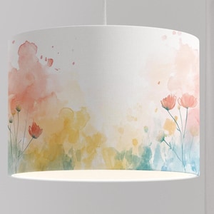 Puede incluir: Una pantalla de lámpara blanca con un diseño de acuarela de flores y follaje rosa, amarillo y azul.