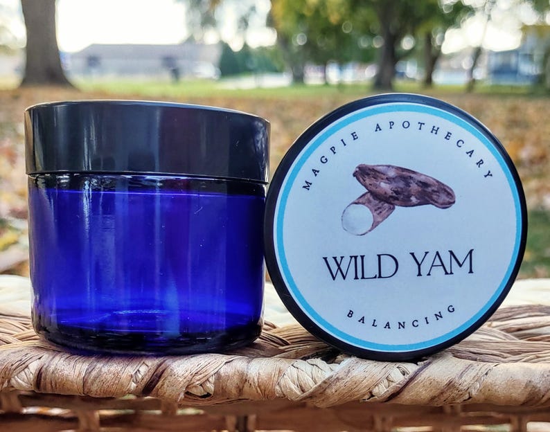 Puede incluir: Un tarro de vidrio azul con tapa negra y una etiqueta blanca que dice "MAGPIE APOTHECARY WILD YAM BALANCING". La etiqueta tambi&eacute;n presenta un dibujo de un &ntilde;ame silvestre.