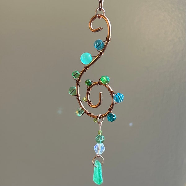 Seaglass spiral swirl suncatcher with copper and green accents and vintage Maine sea glass pendant.