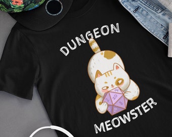 May include: Black t-shirt with a white cat holding a purple 20-sided die. The text "Dungeon Meowster" is printed on the shirt.