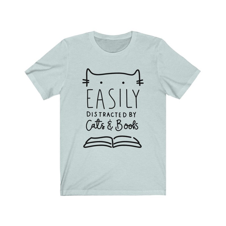 May include: Light blue t-shirt with a black cat illustration and the text "Easily Distracted by Cats & Books".