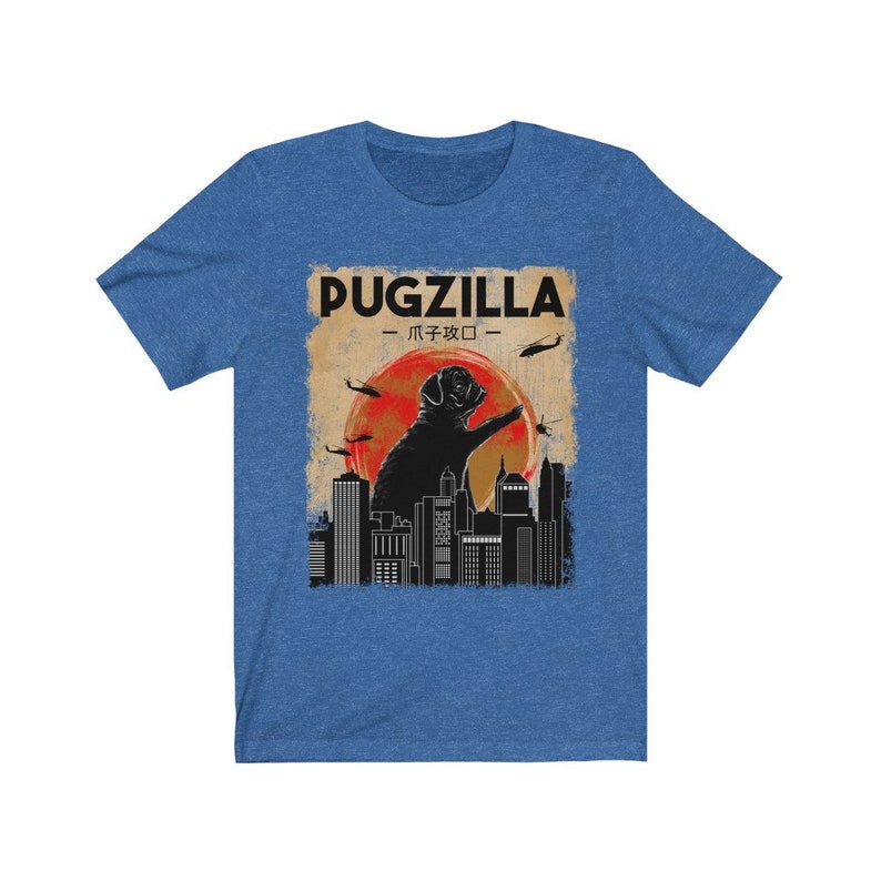 May include: A blue t-shirt with a vintage-style graphic of a pug standing on a city skyline. The graphic says "Pugzilla -  パグジラ - "
