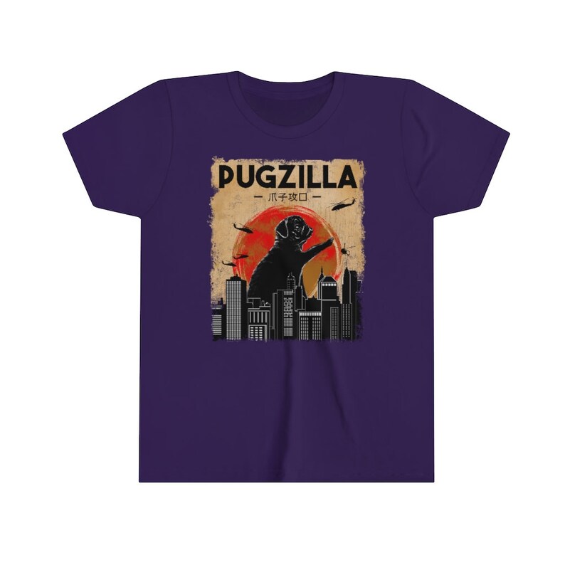 May include: Purple youth t-shirt with a vintage-style graphic of a pug standing on a city skyline with the text "Pugzilla - パグジラ -" above it.