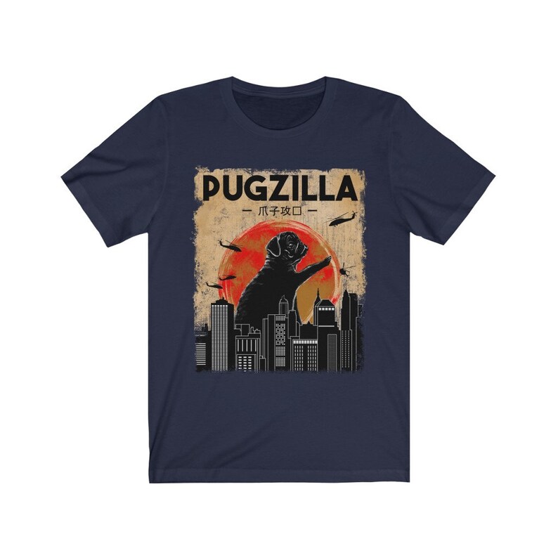 May include: A navy blue t-shirt with a vintage-style graphic of a pug standing on a city skyline. The graphic says "Pugzilla -  パグジラ - ".