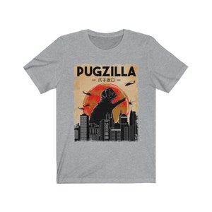 May include: A gray t-shirt with a black and white graphic of a pug standing on a city skyline with the text "Pugzilla -  パグジラ -" above it.
