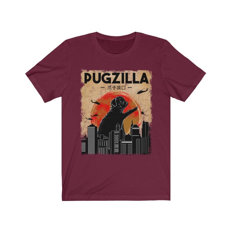 May include: A maroon t-shirt with a graphic of a pug standing on a city skyline. The text "PUGZILLA -  パグジラ - " is above the pug.