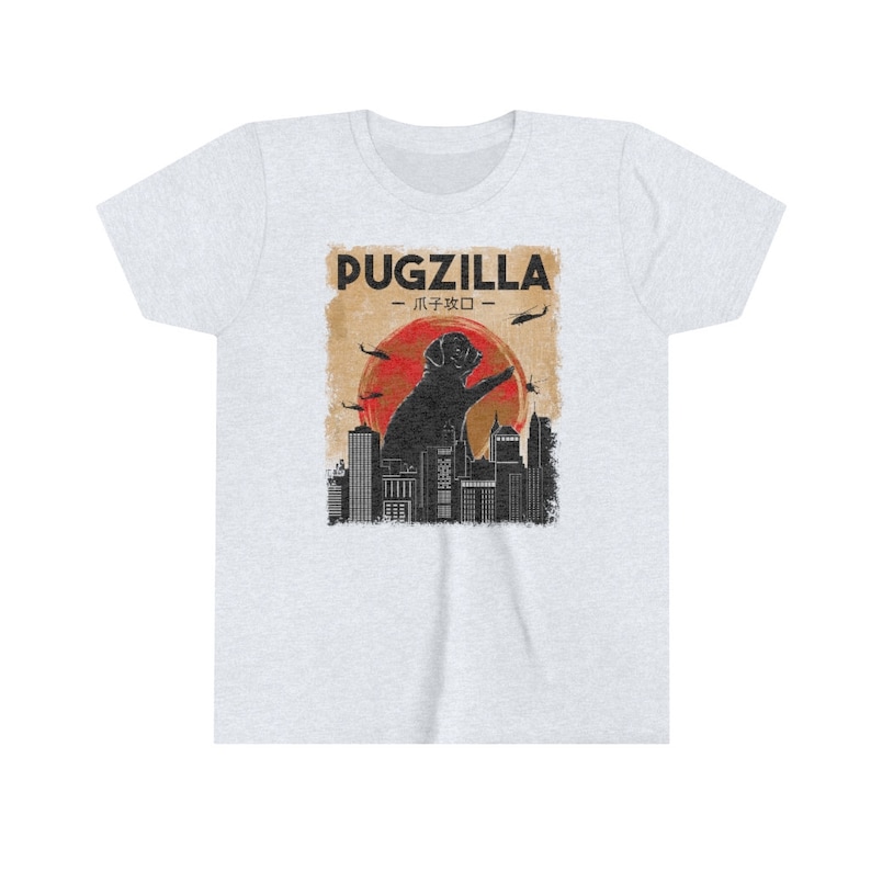 May include: A light grey t-shirt with a graphic print of a black pug standing on a city skyline. The text "PUGZILLA -  パグジラ -" is printed above the pug.