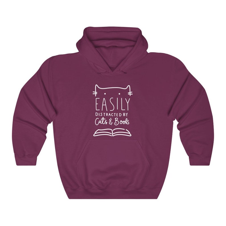 May include: A maroon hooded sweatshirt with a white graphic design that says "Easily Distracted by Cats & Books" with a cat head and an open book.