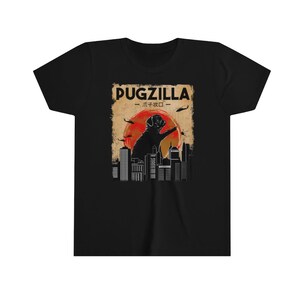 May include: Black t-shirt with a graphic of a pug standing on a city skyline with the text "Pugzilla -  パグジラ -" in a vintage style.