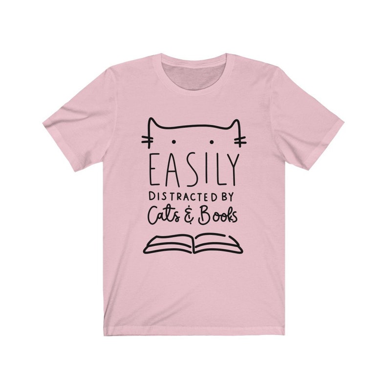 May include: Pink t-shirt with a black cat illustration and the text "Easily Distracted by Cats & Books".