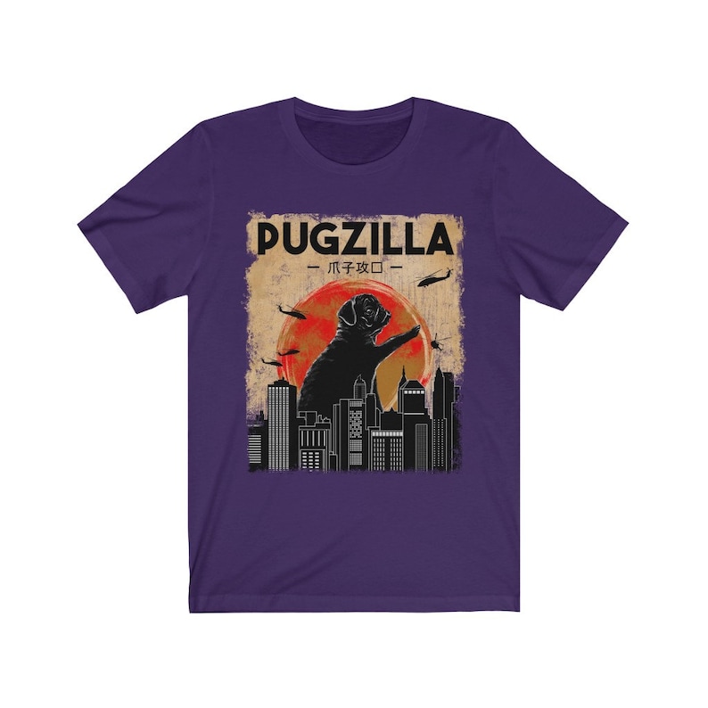 May include: Purple t-shirt with a vintage-style graphic of a pug standing on a city skyline. The graphic says "Pugzilla -  パグジラ - "