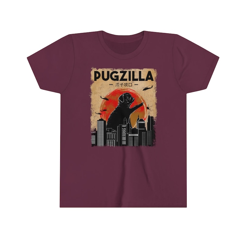 May include: A maroon t-shirt with a graphic of a pug standing on a city skyline with the text "Pugzilla - パグジラ -" printed on the front.