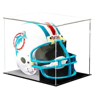 May include: A white football helmet with teal and orange stripes and a teal facemask, displayed in a clear acrylic case. The helmet features the Miami Dolphins logo and the Riddell brand name.