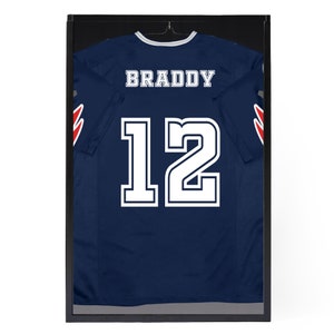 May include: A navy blue jersey with white lettering and the number 12. The name "BRADDY" is on the back of the jersey.