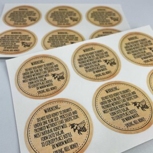 Peut inclure: Une feuille d'&eacute;tiquettes en papier brun avec un avertissement concernant l'alimentation des nourrissons de moins d'un an avec du miel. Les &eacute;tiquettes pr&eacute;sentent une illustration d'abeille et le texte "AVERTISSEMENT : NE PAS DONNER DE MIEL AUX BEBES DE MOINS D'UN AN. TRAITE ET PREPARE SANS INSPECTION DE L'ETAT. LA PLUPART DU MIEL NATUREL SE TRANSFORMERA EN SUCRE. POUR LIQUEFIER, PLACER LA BOUTEILLE DANS DE L'EAU CHAUDE. MIEL DE SPRING HILL."