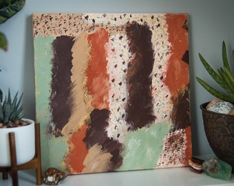 May include: Abstract painting on canvas with brown, orange, gold, green, and white paint. The painting has a textured surface and a modern style.