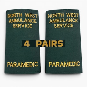 May include: Two dark green paramedic epaulettes with gold embroidered text reading "NORTH WEST AMBULANCE SERVICE" and "PARAMEDIC". The image also shows the text "4 PAIRS" in gold.