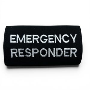 May include: A black rectangular patch with the white embroidered text "EMERGENCY RESPONDER". The patch has rounded corners. The text is centrally aligned and easy to read. The fabric appears to be hard-wearing.