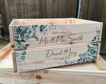 May include: A wooden crate with a eucalyptus design and the text "Best wishes for Mr & Mrs Smith Daniel & Lucy 23rd April 2024".