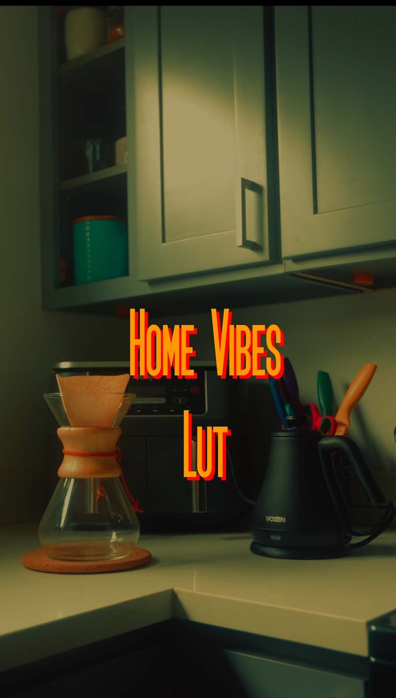 May include: A kitchen counter with a glass coffee maker, a black electric kettle, and a black coffee maker. The text "HOME VIBES LUT" is written in orange and red letters on the counter.