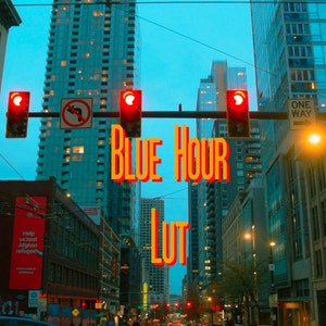 May include: A city street scene at dusk with tall buildings and traffic lights. The text "BLUE HOUR LUT" is superimposed over the image.